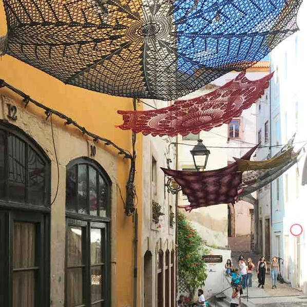 Public art, Coimbra - community-made crochet turns a familiar craft into shade, colour and street decoration.
