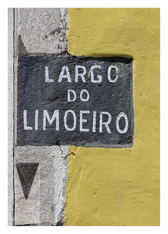 A word I didn't understand - but a clue in the colour: Yellow walls and hand-rendered lettering at Largo do Limoeiro / Lemon Tree Square.